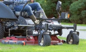 Closeup of man's feet and bottom of riding lawn mower