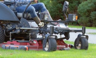 Weekly Mowing Closeup of man's feet and bottom of riding lawn mower