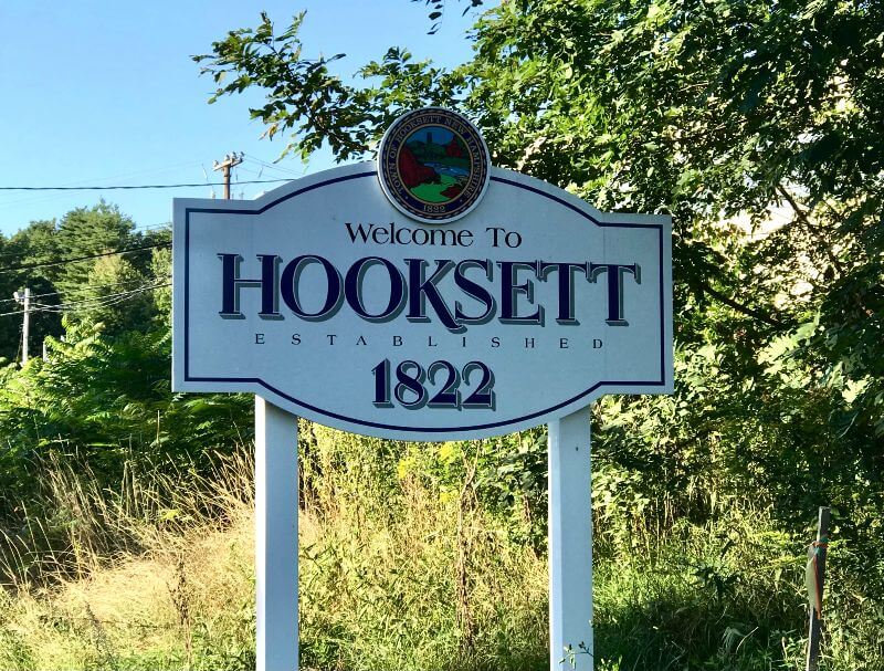 White wood sign with words Welcome to Hooksett 1822