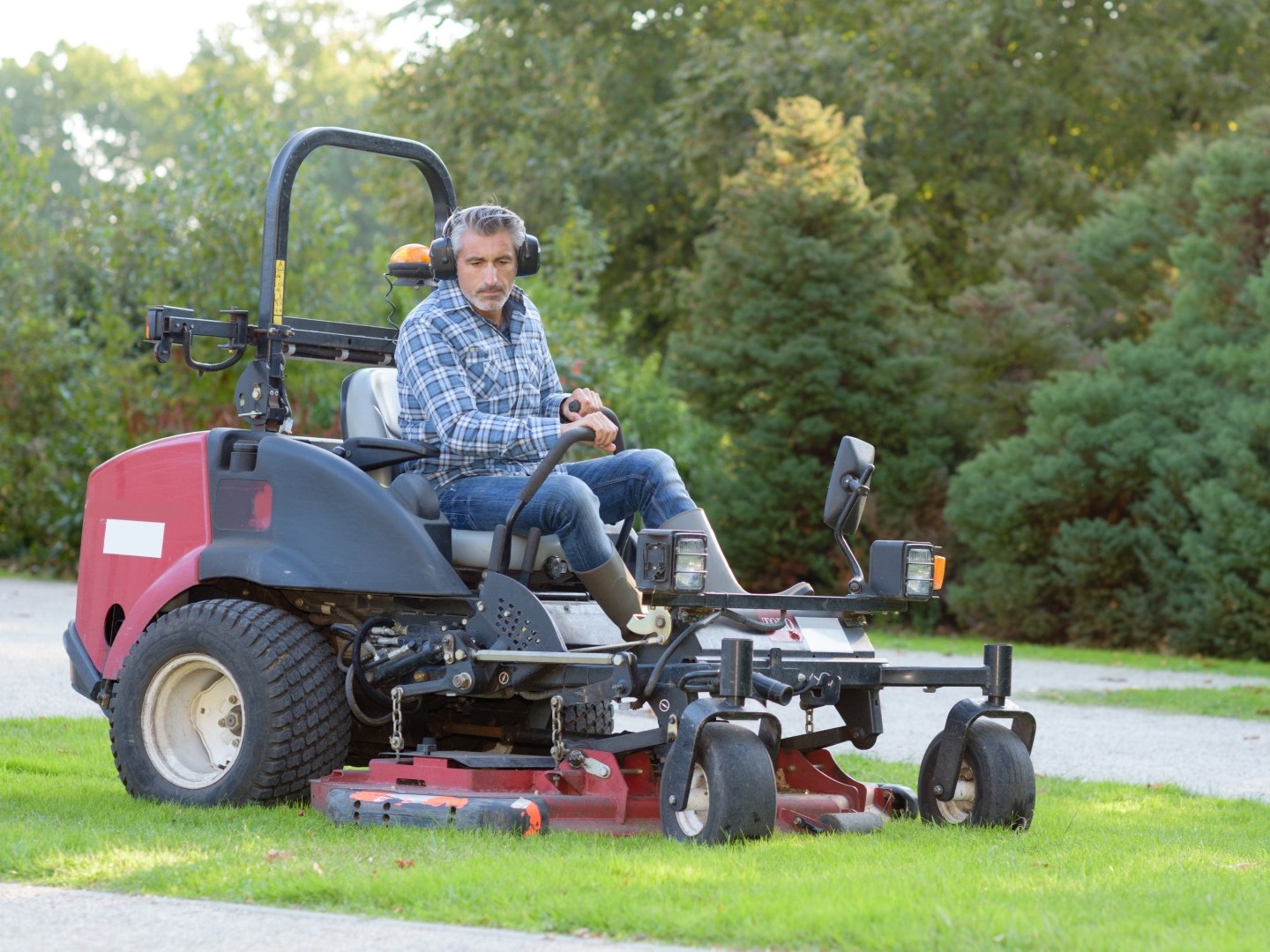 man on rider mower cutting grass