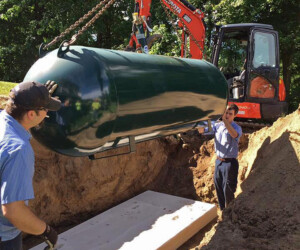 Worker running machine installing propane tank
